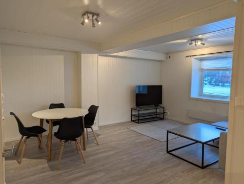 a living room with a table and chairs and a tv at Central Station Retreat in Narvik