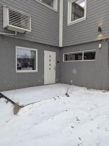 a house with snow on the ground in front of it at Central Station Retreat in Narvik