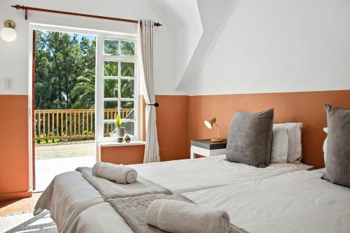 een slaapkamer met een groot bed en een raam bij Farmhouse in Kaapstad