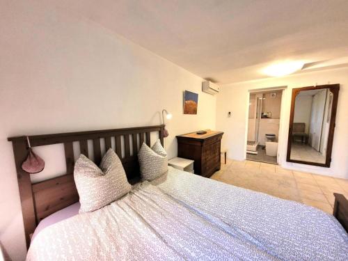 Gîte de France Le noyer 2 épis - Gîte de France 2 personnes MAE-9474 في Saint-Germain-les-Vergnes: غرفة نوم بسرير كبير ومرآة كبيرة