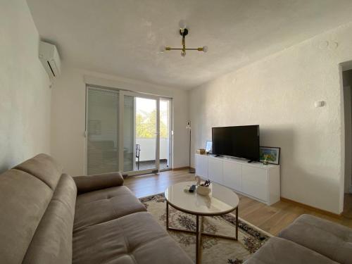 特雷比涅Leutar Central的客厅里有一张沙发和一张桌子。