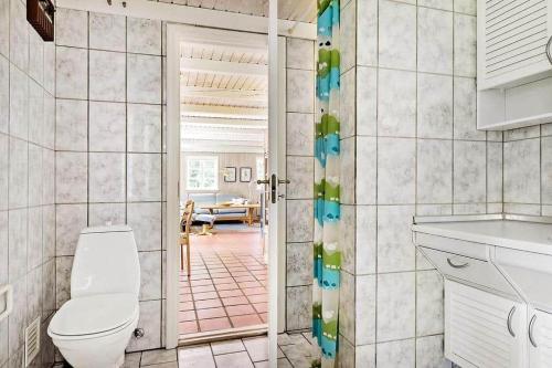 a bathroom with a toilet and a door to a room at 10858-Ulfborg-Raketvejen-41 in Øhuse
