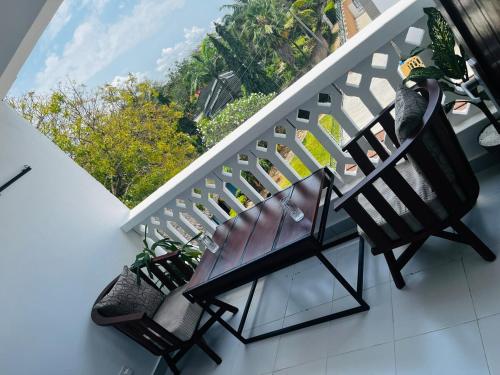 a balcony with two chairs and a staircase at Ntates Place Diani Beach in Diani Beach