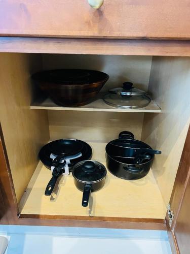 a cabinet with two pots and pans on a shelf at Hogar in Port Richey