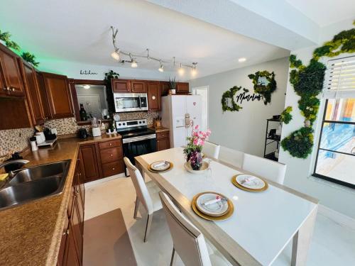 a kitchen with a white table with chairs and a sink at Hogar in Port Richey