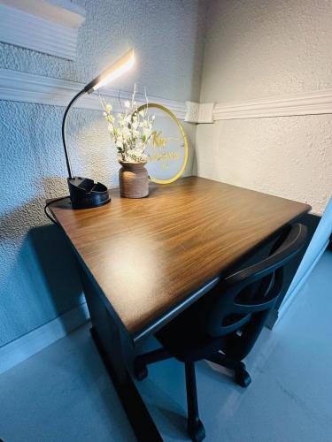 a desk with a lamp and flowers on it at Hogar in Port Richey