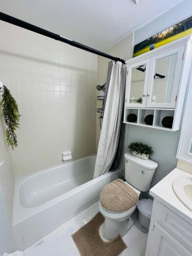 a bathroom with a tub and a toilet and a sink at Hogar in Port Richey