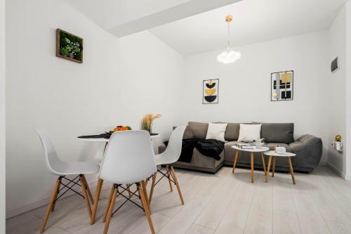 a living room with a couch and a table and chairs at NeoLoft 1st in Popeşti-Leordeni