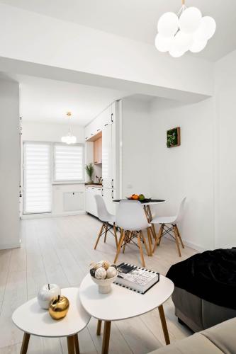 a white living room with white tables and chairs at NeoLoft 1st in Popeşti-Leordeni