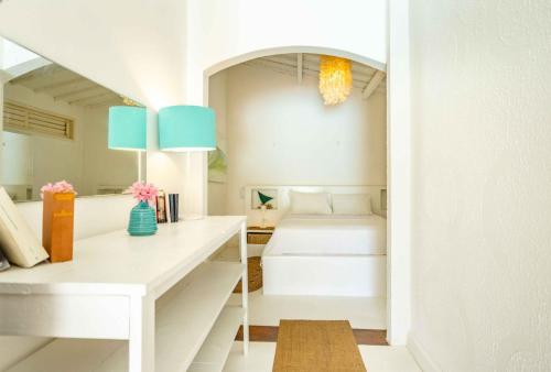 a white room with a white desk and blue lamps at Pousada Duna Beach in Jericoacoara