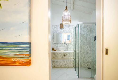 a bathroom with a painting of the ocean at Pousada Duna Beach in Jericoacoara
