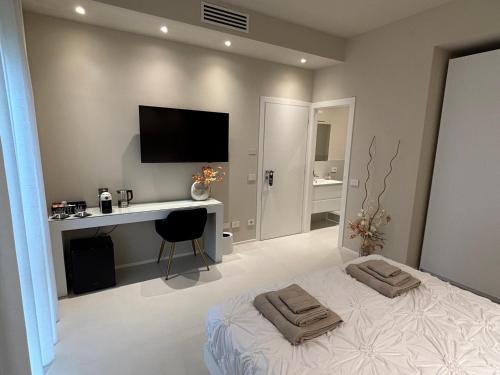 a bedroom with a bed and a desk and a television at Salotto Santa Franca in Piacenza