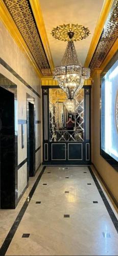 a large hallway with a chandelier and a room at Апартамент in Aktau