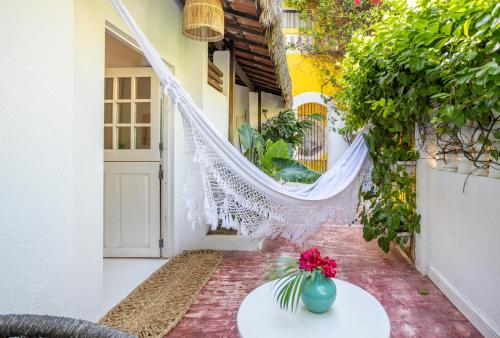 a balcony with a white table and flowers on it at Pousada Duna Beach in Jericoacoara