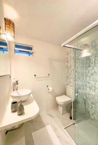 a bathroom with a sink and a glass shower at Pousada Duna Beach in Jericoacoara
