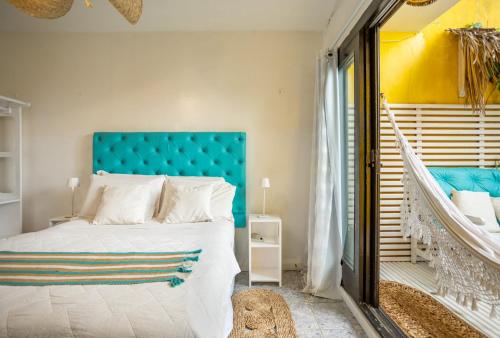 a bedroom with a large bed with a blue headboard at Pousada Duna Beach in Jericoacoara