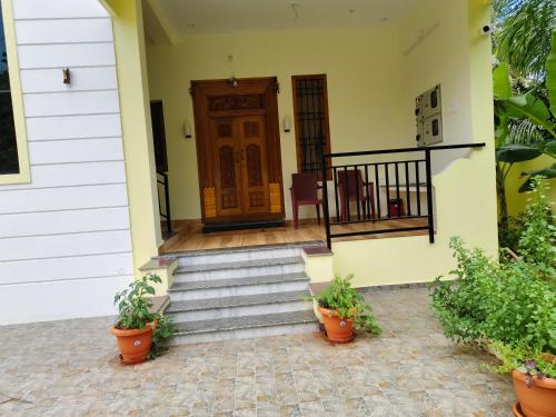a front door of a house with stairs and plants at Ecstasy Homestay Puducherry in Puducherry