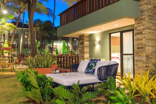 a white couch sitting outside of a building at Hotel Solar Porto de Galinhas in Porto De Galinhas