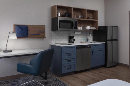 a kitchen with a sink and a refrigerator at Candlewood Suites St. Robert by IHG in Saint Robert