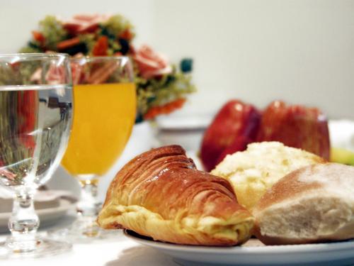 a plate of croissants and bread and glasses of wine at Hotel Cruz Alta in Fátima