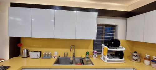 a kitchen with white cabinets and a sink at Spacious 2BR Portion with Rooftop Gulshan e Iqbal Block 7 in Karachi