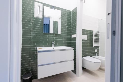 baño con lavabo, aseo y azulejos verdes en Rose of pyramid, en Roma