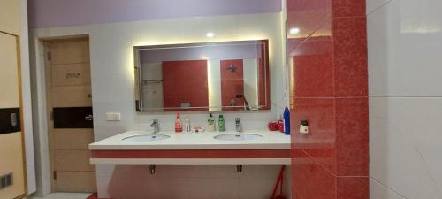 a bathroom with two sinks and a mirror at Spacious 2BR Portion with Rooftop Gulshan e Iqbal Block 7 in Karachi