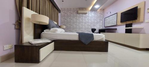 a hotel room with a bed and a tv at Spacious 2BR Portion with Rooftop Gulshan e Iqbal Block 7 in Karachi