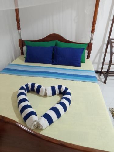 a heart shaped towel laying on a bed at Viraj's Garden in Tangalle