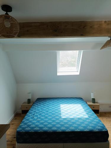 une chambre avec un lit bleu avec une fenêtre dans l'établissement Charmante maisonnette, à Saint-Amand-les-Eaux