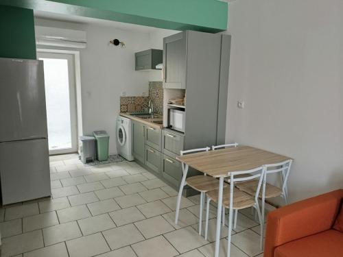 una cucina con un tavolo e sedie in una stanza di Charmante maisonnette a Saint-Amand-les-Eaux