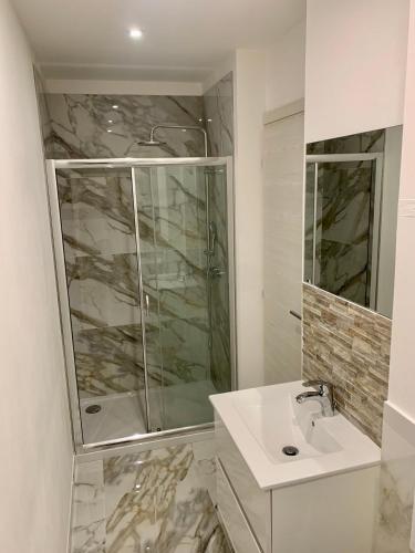 a white bathroom with a shower and a sink at 1 BEDROOM APARTMENT iN ViLLA MATEKA in Roquebrune-Cap-Martin