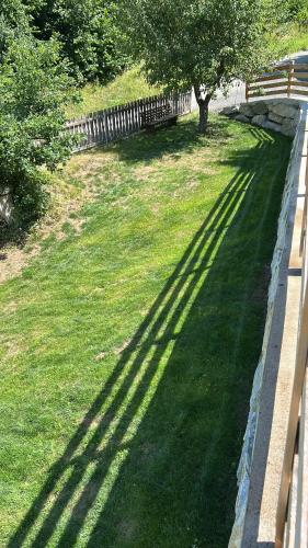 a shadow of a fence on a field of grass at Panoramablick Hütte in Scheifling