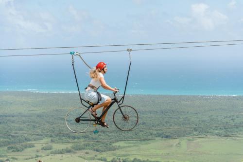 a woman riding a bike in a zip line at Viva Miches by Wyndham, a Trademark All Inclusive Resort in Miches
