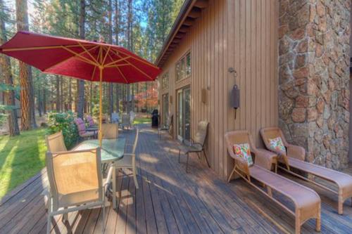 a deck with a table and chairs and an umbrella at Rock Ridge 39 in Black Butte Ranch