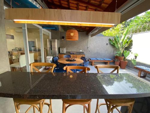 a dining room with a black table and chairs at Casa de Praia Pé na Areia Boiçucanga 6 in São Sebastião
