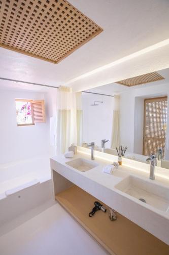 a bathroom with two sinks and a large mirror at Casitas in Careyes in Careyes