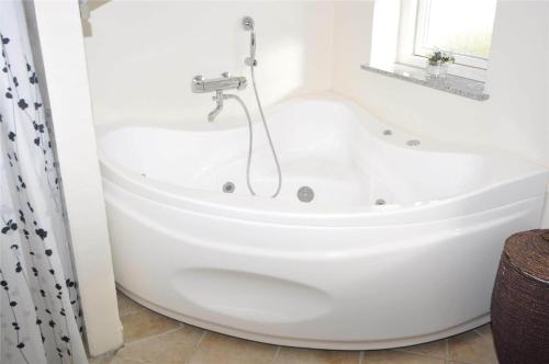 a white bath tub in a bathroom with a window at 10850-Ulfborg-Vester-Mosevej-82 in Øby