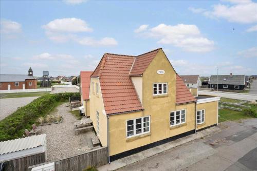 a yellow and orange house with a red roof at 70421-Ulfborg-Kirkevej-2-1-sal in Thorsminde