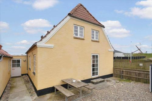 a yellow house with a bench in front of it at 70421-Ulfborg-Kirkevej-2-1-sal in Thorsminde