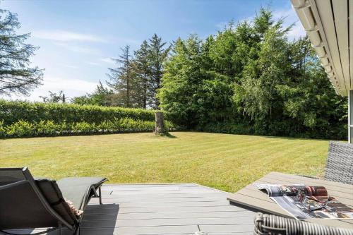 a patio with a table and chairs and a lawn at 30036-Ulfborg-Oster-Skovvej-149 in Sønder Nissum