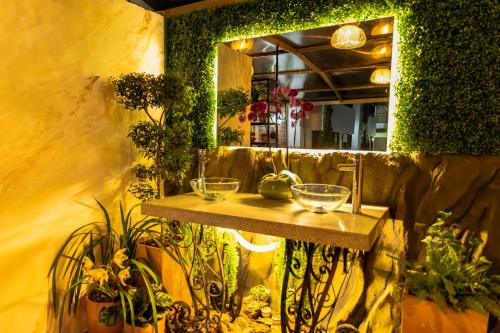 a mirror on the side of a room with plants at Hotel Bahia Del Faro in Guatapé