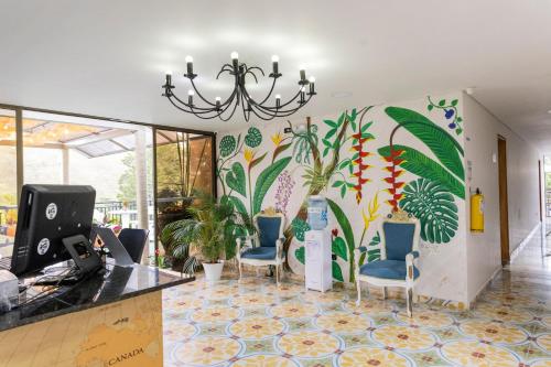 a lobby with a mural of plants on the wall at Hotel Bahia Del Faro in Guatapé