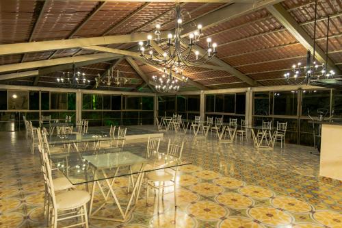 a banquet hall with tables and chairs and a chandelier at Hotel Bahia Del Faro in Guatapé