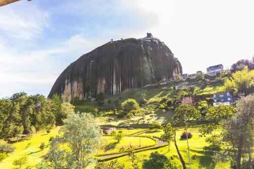 a mountain in the middle of a green field at Hotel Bahia Del Faro in Guatapé