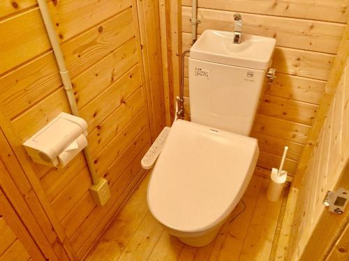 La salle de bains en bois est pourvue de toilettes et d'un lavabo. dans l'établissement Shirakaba no mori Cottage - Vacation STAY 60815v, à Abashiri