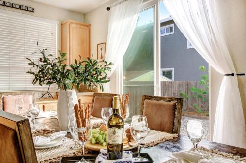 a dining room table with a bottle of wine on it at Healdsburg Winemaker's Home in Windsor