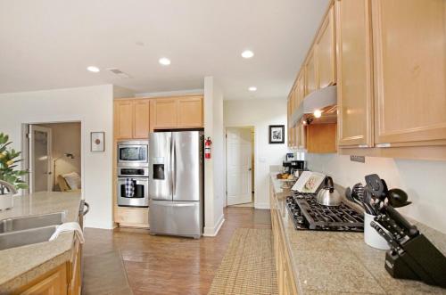 a kitchen with wooden cabinets and a stainless steel refrigerator at Healdsburg Winemaker's Home in Windsor