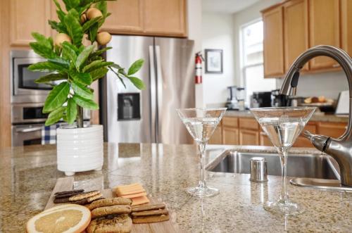 a kitchen counter with two wine glasses and cookies at Healdsburg Winemaker's Home in Windsor