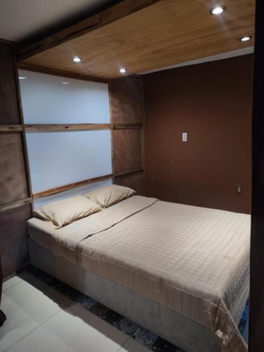 a bed in a room with a large window at Departamento zona centro in Aguascalientes
